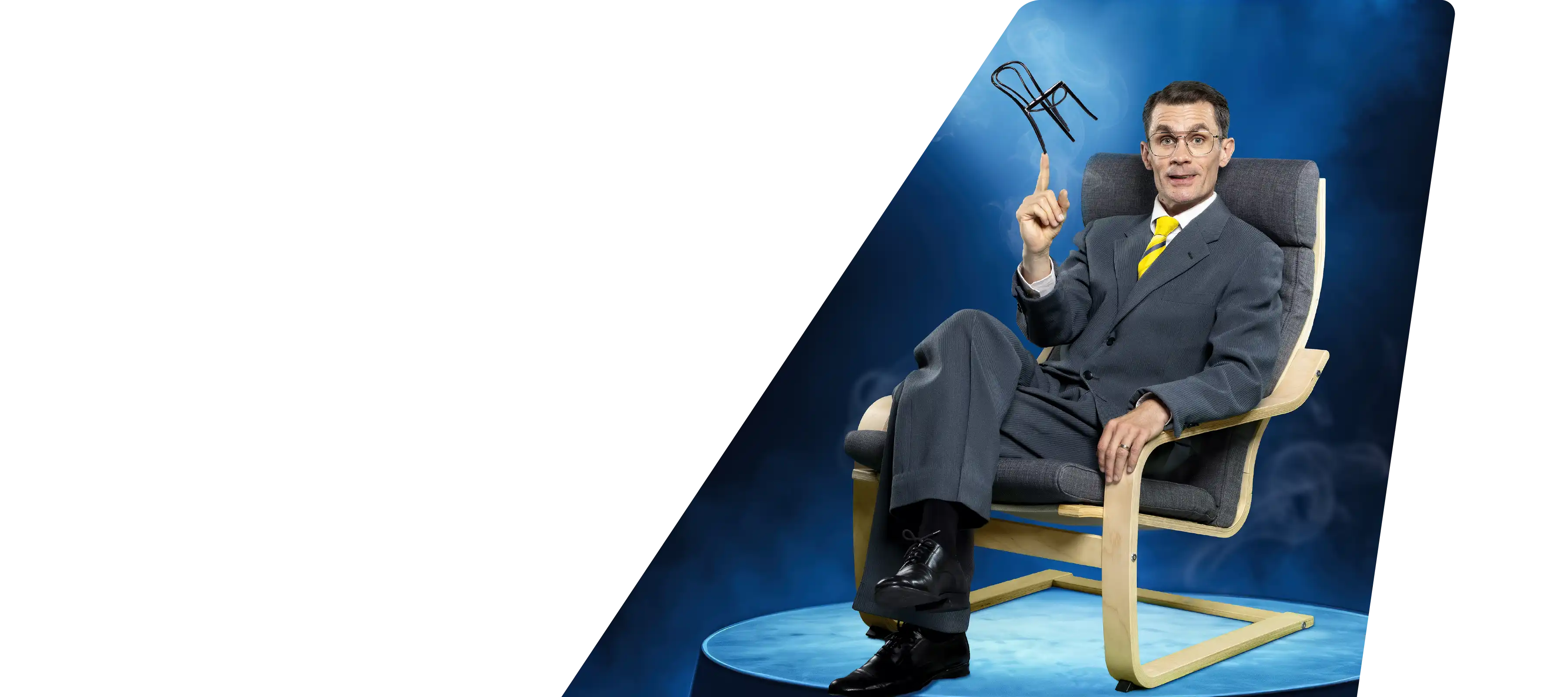 Skådespelaren Robert som Ingvar Kamprad sittandes på en IKEA stol.