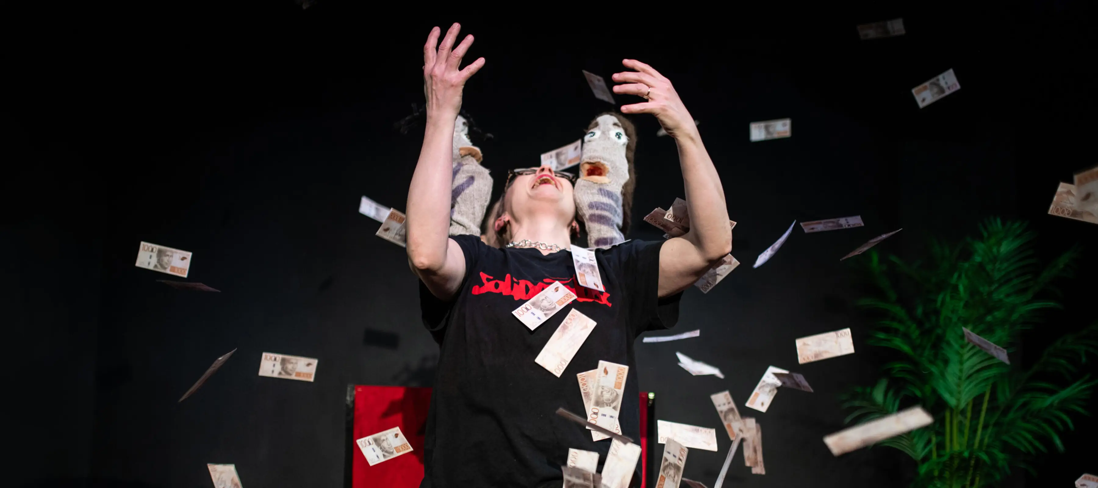 Kvinna med armarna i luften och massa sedlar som flyger omkring henne.