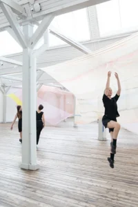 Tre dansare i öppen lokal.